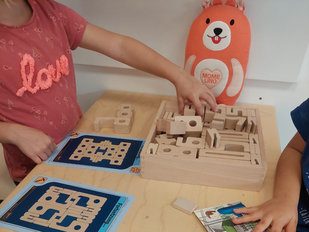 Momelino: Kinder spielen mit dem MINT- und BNE-Bildungsprogramm wiKilino und lernen spielerisch mit Holzbausteinen.